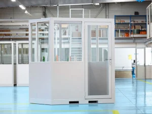 Cabine d'atelier palettisable 2x1.5m grise NOVOCAB positionnée dans un entrepôt industriel.