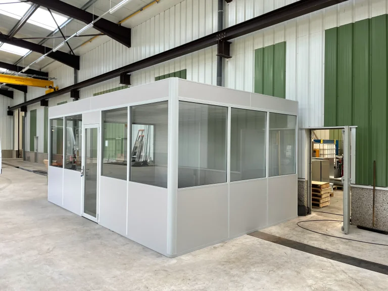 Cabine d’atelier en kit vitrée montée dans un atelier industriel équipé d’un pont roulant