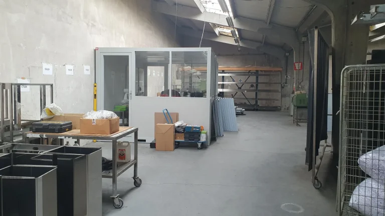 Cabine vitrée installée dans un atelier équipé de mobilier en inox