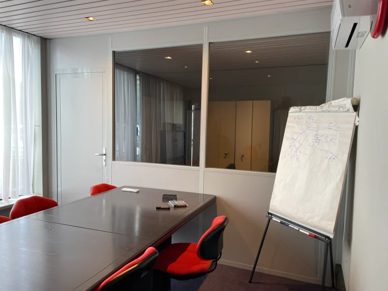 Salle de réunion fermée par une cloison semi-vitrée, allège pleine et vitrage sur toute la longueur