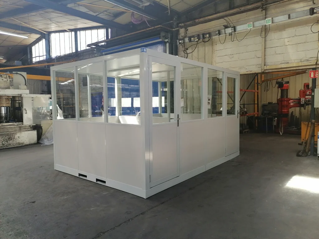 Grande cabine d’atelier palettisable vitrée, posée au cœur d’un atelier de production industriel