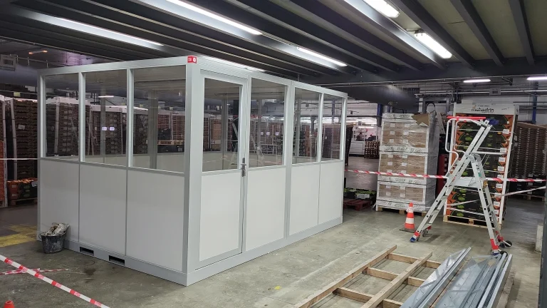 Longue cabine palettisable vitrée en cours de mise en service dans un entrepôt de stockage
